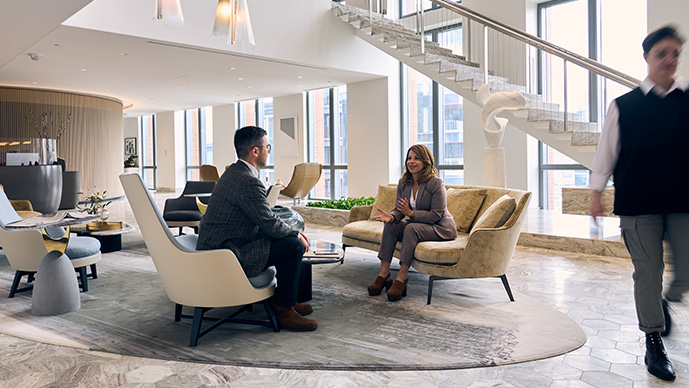 Male and female sitting on couch in Foley Hoag lobby.